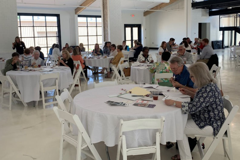 Participants in the CARE Aware workshop sitting at tables in a large room