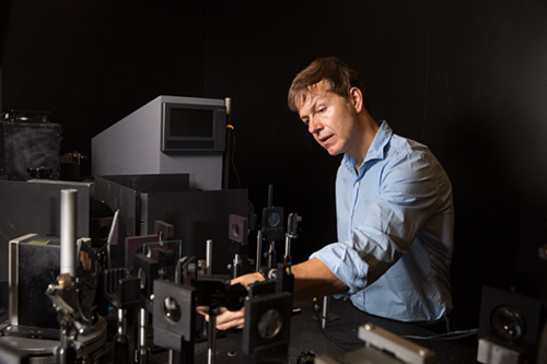 Man working on optic device