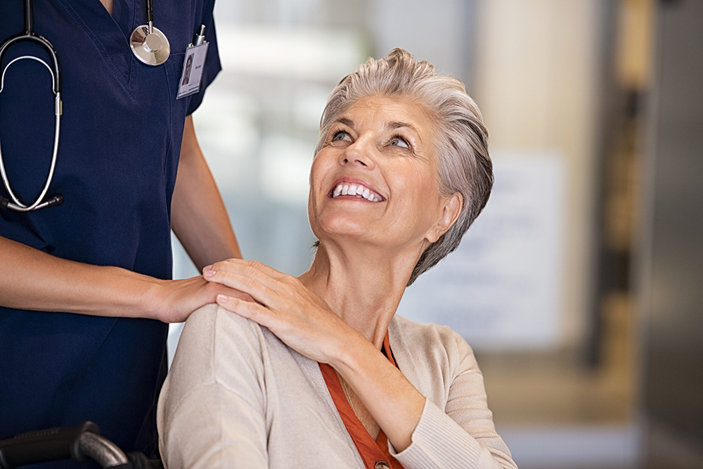 A woman looking up at a nurse.